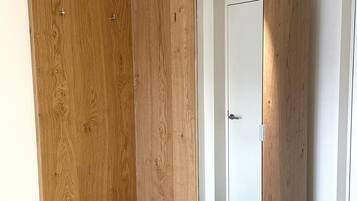 Una habitación moderna con un armario de madera y una puerta de armario con espejo.