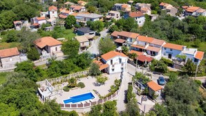 An aerial view of a residential area with houses, a swimming pool, and a church. - Tranquil Getaway Polje Villa With Pool (Dobrinj)