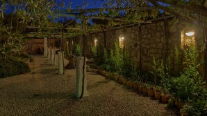 A garden with a stone wall, potted plants, and a gravel path. - Tranquil Getaway Polje Villa With Pool (Dobrinj)