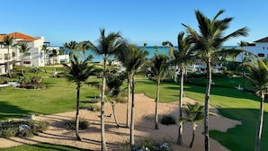 A resort with a beach view, palm trees, and a well-maintained lawn. - Apt With 2BR and Beach Access in Punta Palmera (Punta Cana)