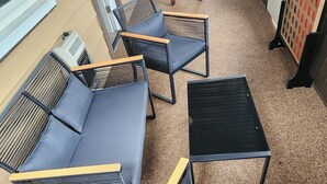 Una veranda con una zona divano, un tavolino e un tavolo da calcio.