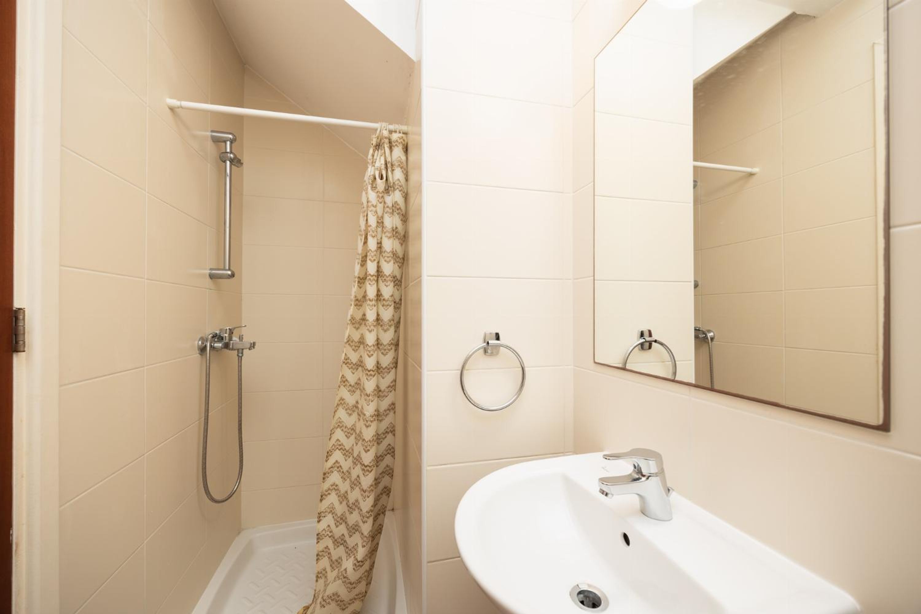 A bathroom with a shower, a sink, and a mirror.