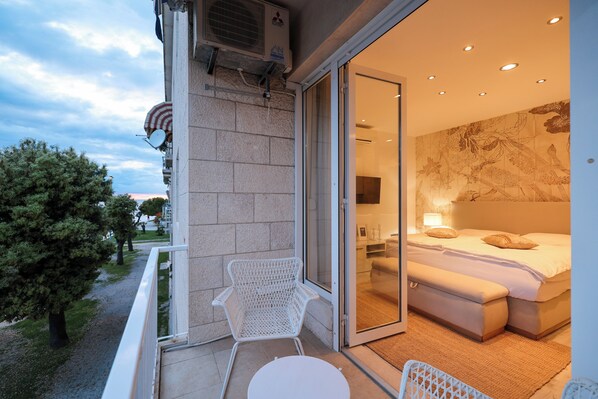 Relax on the balcony with a large bed and comfortable seating area.