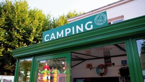 A green storefront with a sign that reads "CAMPING" and a logo indicating camping services. - Camping de Thoissey - Val de Saône (Saint-Didier-sur-Chalaronne)