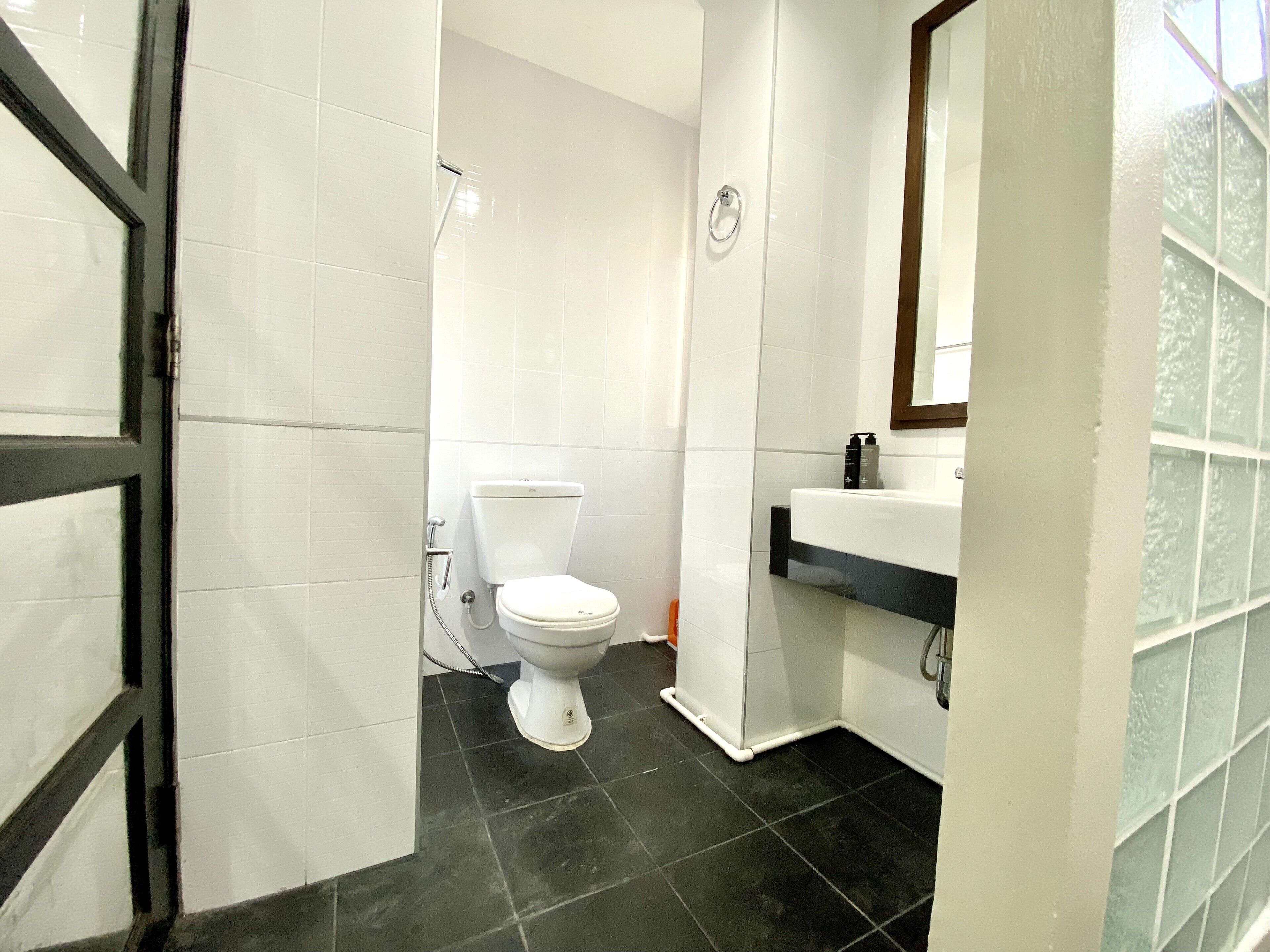 A bathroom with a toilet, a sink, and a shower.