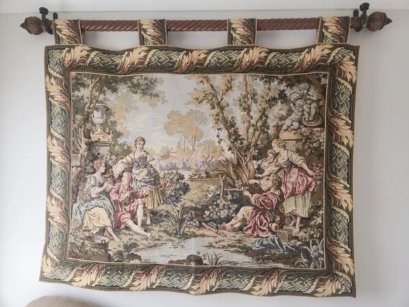 A framed artwork depicting a pastoral scene with figures in period clothing. - King's Loft, City Center Raleigh (Raleigh)
