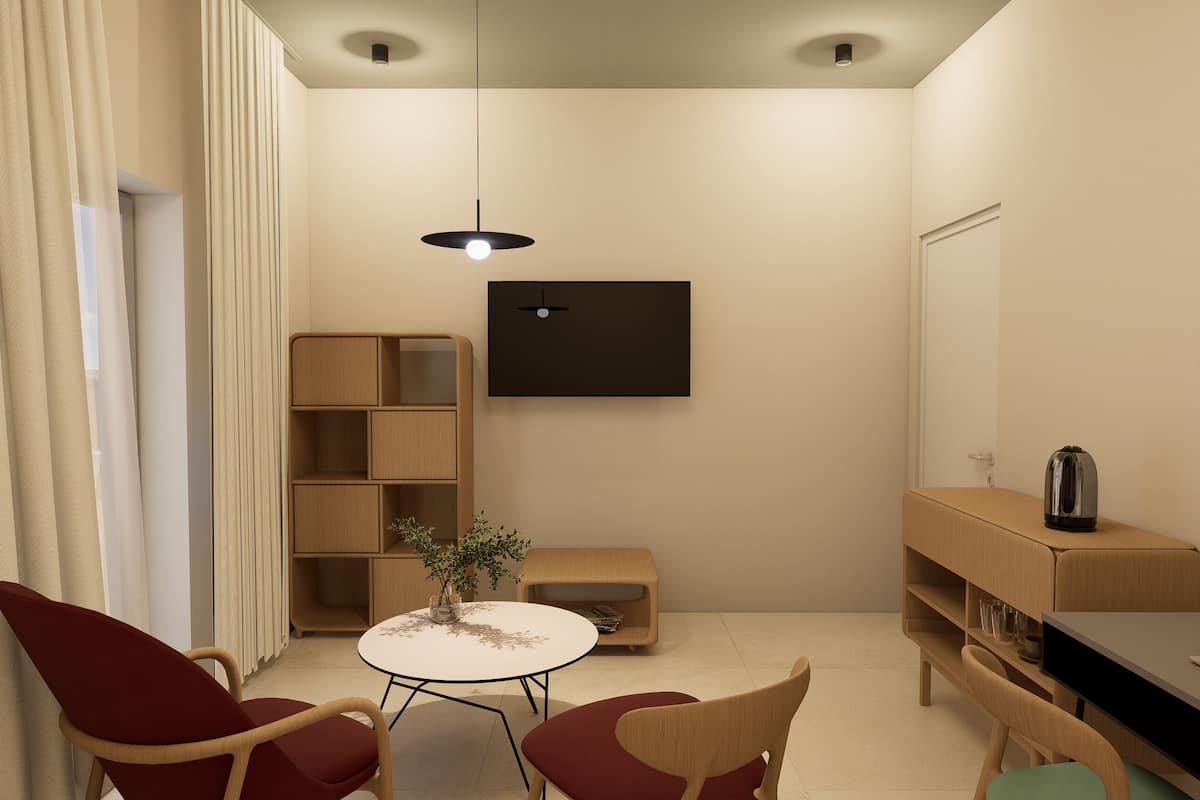 A modern living room with a round table, two red chairs, a wooden bookshelf, a small side table with a plant, and a flat-screen TV mounted on the wall.
