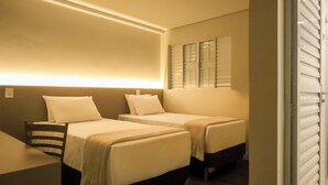 Una habitación de hotel con dos camas individuales, un escritorio y una silla.