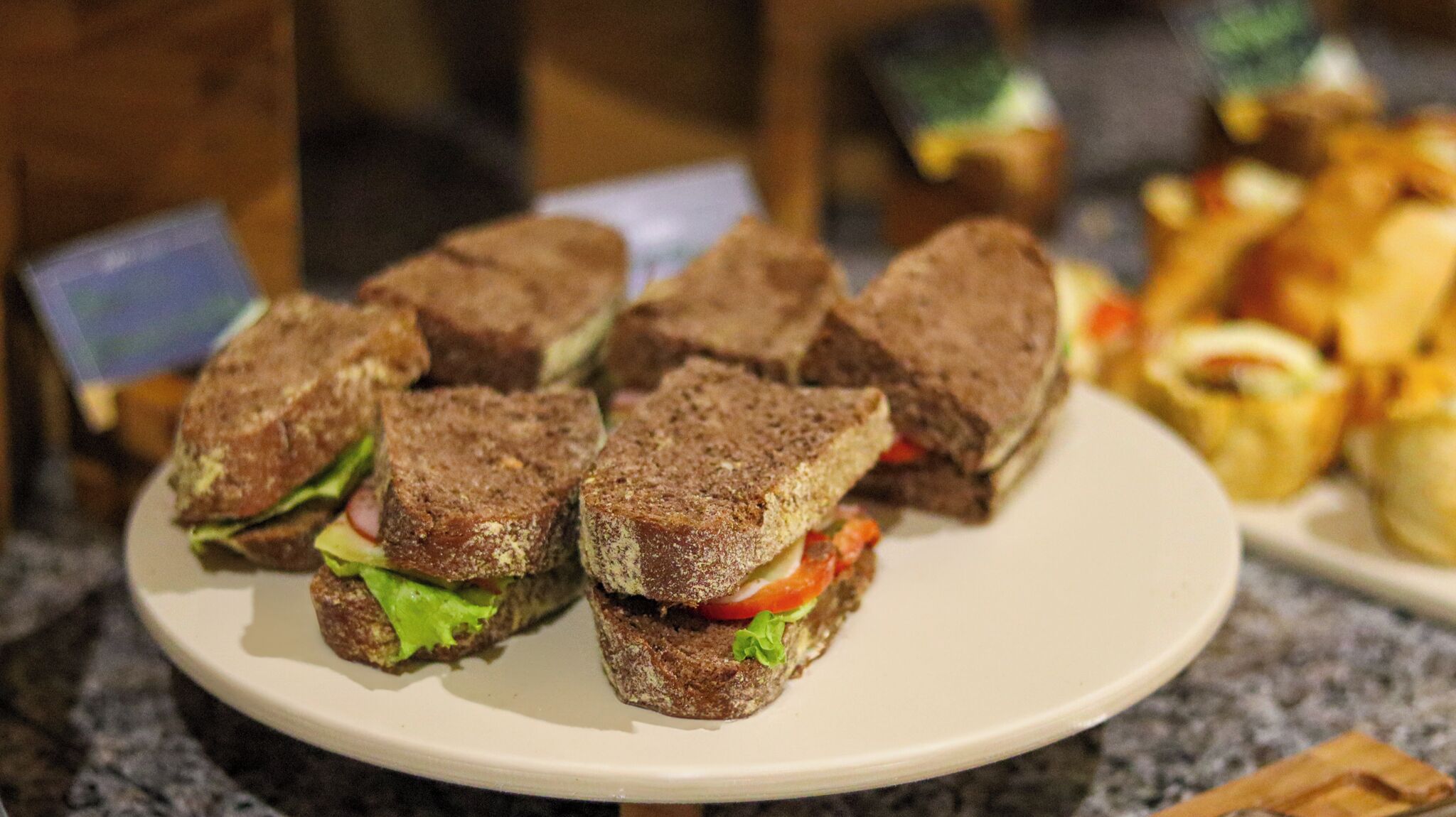 Ein Teller Sandwiches mit Salat und Tomate.