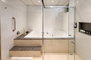 A modern bathroom with a glass-enclosed shower, a marble countertop, and a built-in bathtub. - Hotel Greenville by Slim Hotéis (Primavera do Leste)