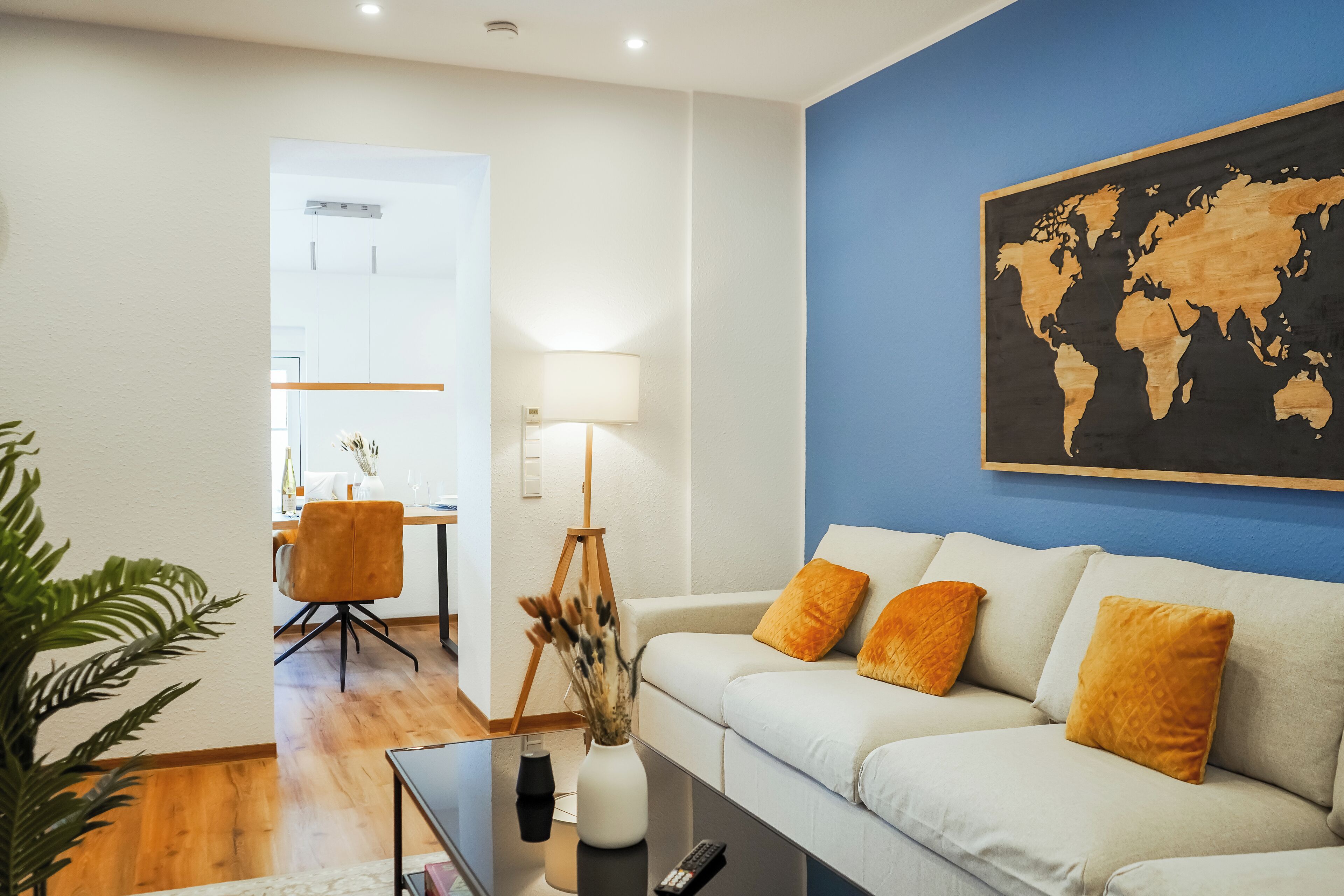 Una sala de estar moderna con un sofá, una mesa de centro y un mapa del mundo en la pared.