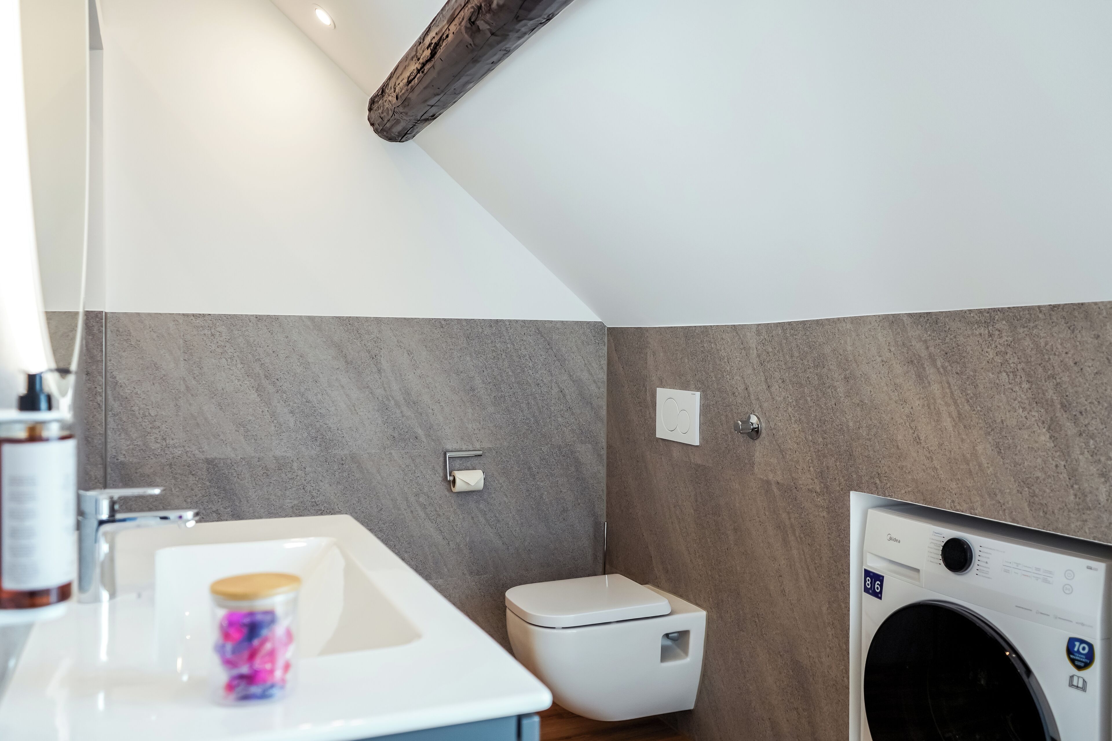 Un baño moderno con lavamanos, inodoro y lavadora.