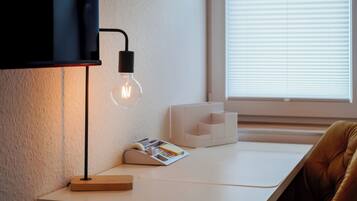 Et moderne arbejdsområde med et skrivebord, en lampe og en stol.