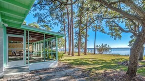 Un espacio de estar techado al aire libre con vista al lago.