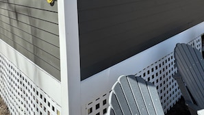 Un bâtiment à l’extérieur de couleur gris foncé, avec des encadrements de fenêtres blancs et le chiffre « 18 » sur le côté.