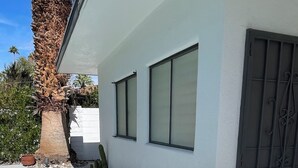 A modern house with a concrete pathway, a cactus, and a metal gate. - Charming 3-bedroom house with AC and WiFi in Palm Springs (Palm Springs)