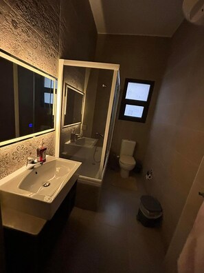 A bathroom with a sink, mirror, and toilet. - Spacious 3-bedroom apartment with AC and WiFi in charming Fifth Square AlMarasem (Fifth Square Al Marasem)