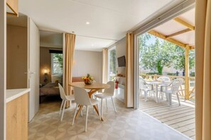 Ein Zimmer mit Essbereich, einem Bett und Blick ins Freie.
