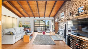 A modern living room with a grey sofa, wooden coffee table, and a fireplace. - 93 Montague Ave Kianga (Kianga)