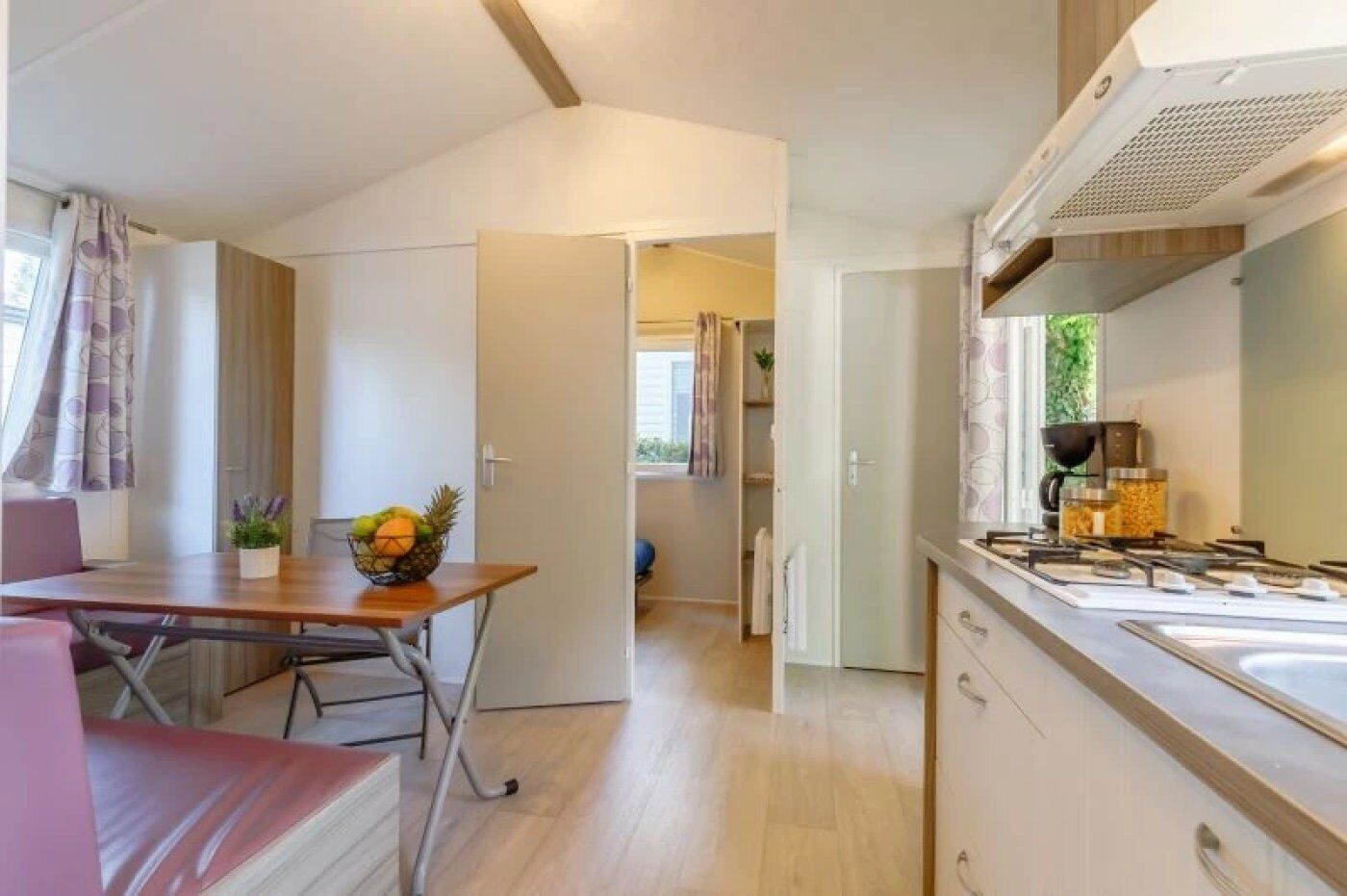 Een kleine keuken met een eethoek, een zichtbaar raam en een kitchenette.