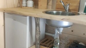 A compact kitchen with a built-in microwave, a sink, and a small refrigerator. - ZEcamping 2* piscine couverte locatif 4 pers (Bar-sur-Aube)