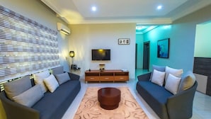 A modern living room with two sofas, a coffee table, a TV, and a cabinet. - Haute ApartHotel (Lagos)