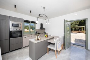 A modern kitchen with a central island, built-in appliances, and a view to the outdoors.