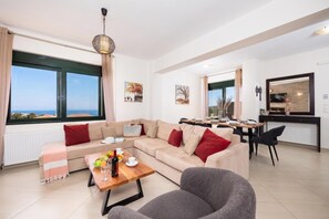 Una sala de estar moderna con un sofá, una mesa de comedor y una zona de cocina.
