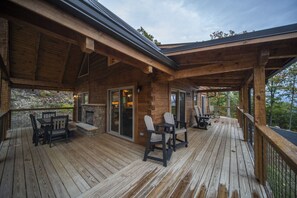 A wooden deck with outdoor seating and a fireplace. - 3 Bed | 4 Bath Mountain Escape in Wears Valley (Sevierville)