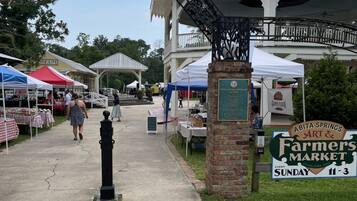A Farmers Market with a sign indicating it is held every Sunday from 11-3.