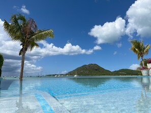 A clear blue sky, a swimming pool, and a mountain in the background.