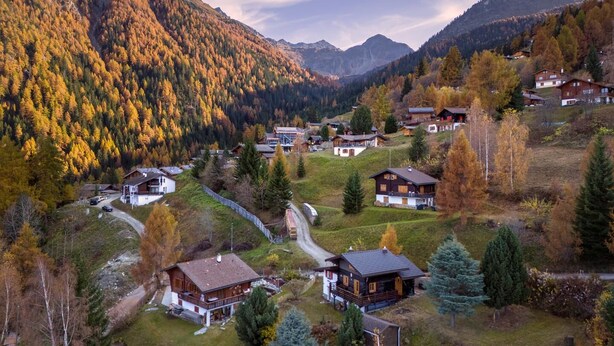 A mountainous village with wooden houses, a winding road, and autumn foliage. - Chalet Les Aragnes Family Chalet La Tzoumaz (Riddes)