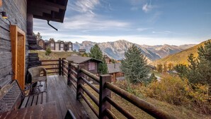 A wooden cabin with a deck overlooking a mountainous landscape. - Chalet Les Aragnes Family Chalet La Tzoumaz (Riddes)