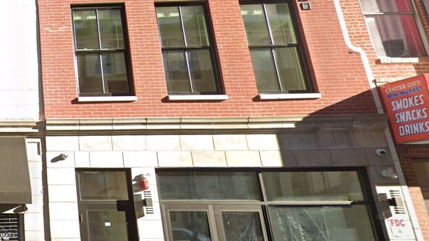A red brick building with multiple windows and a storefront.