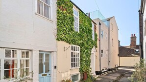 A narrow street with white and beige buildings, one with ivy-covered walls. - Georgian Coach House in a Prime Location in Deal (Kent)