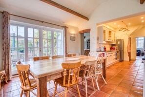 Farmhouse dining table for gatherings, with garden views and easy kitchen flow