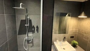 A modern bathroom with a shower, a sink, and a mirror. - Alfred Suites is an elegant, upscale residence ideally located in the vibrant he (Dijon)
