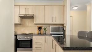 A modern kitchen with light wood cabinets, stainless steel appliances, and a black granite countertop. - Villa Italia Getaway,  Pool, Gym, Netflix, Wifi (Cape Town)