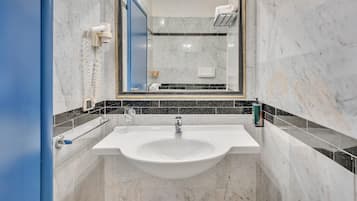 A bathroom with a white sink, a mirror, and a towel rack.