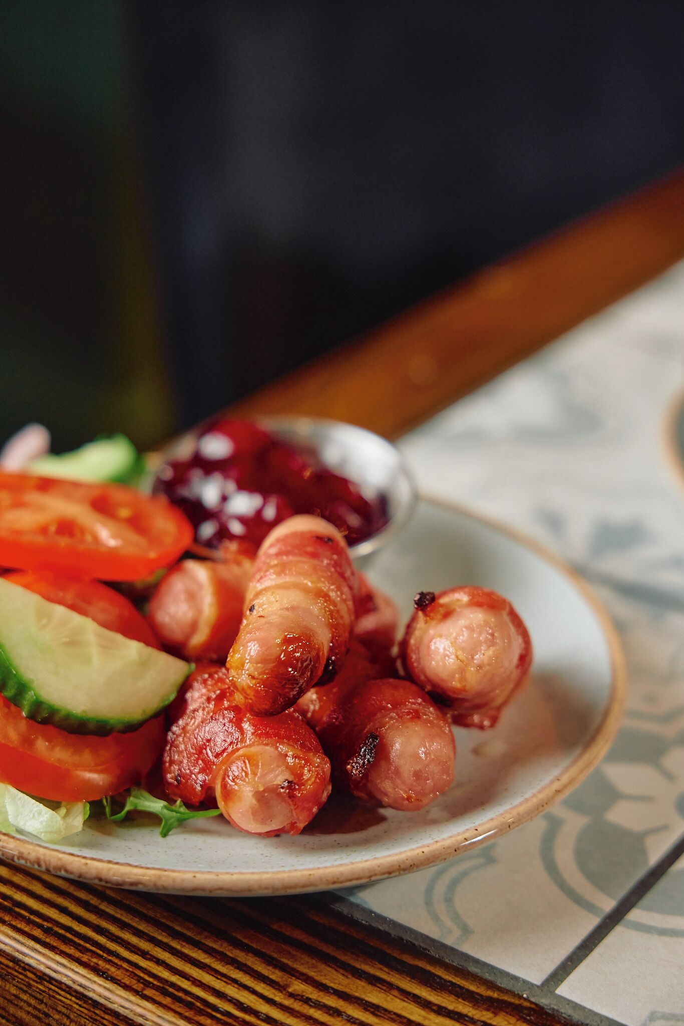 Ein Teller mit Wurst und Gemüse, dazu eine kleine Schüssel Soße.