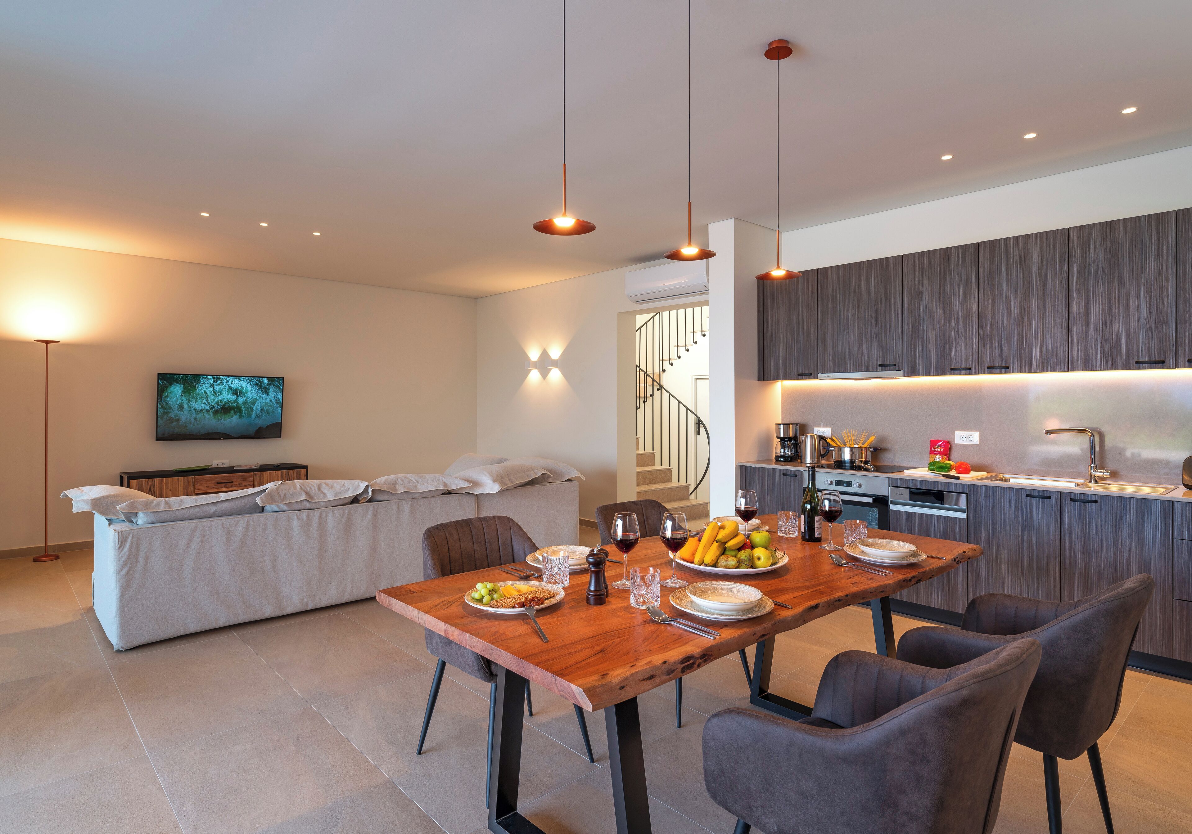 Un espacio de estar moderno con comedor, cocina y sofá.