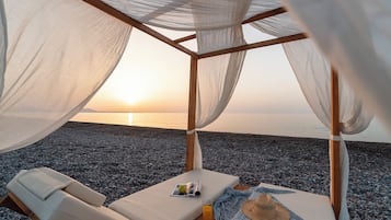 Na praia, barracas de praia de cortesia, espreguiçadeiras, guarda-sóis