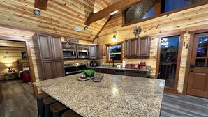 Eine geräumige Küche mit Granit-Arbeitsplatten, Edelstahlgeräten und Holzschränken.