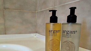 Two bottles of Argan Source products, a shower gel and a shampoo balm, on a white bathroom sink. - Orio welcome (Grassobbio)