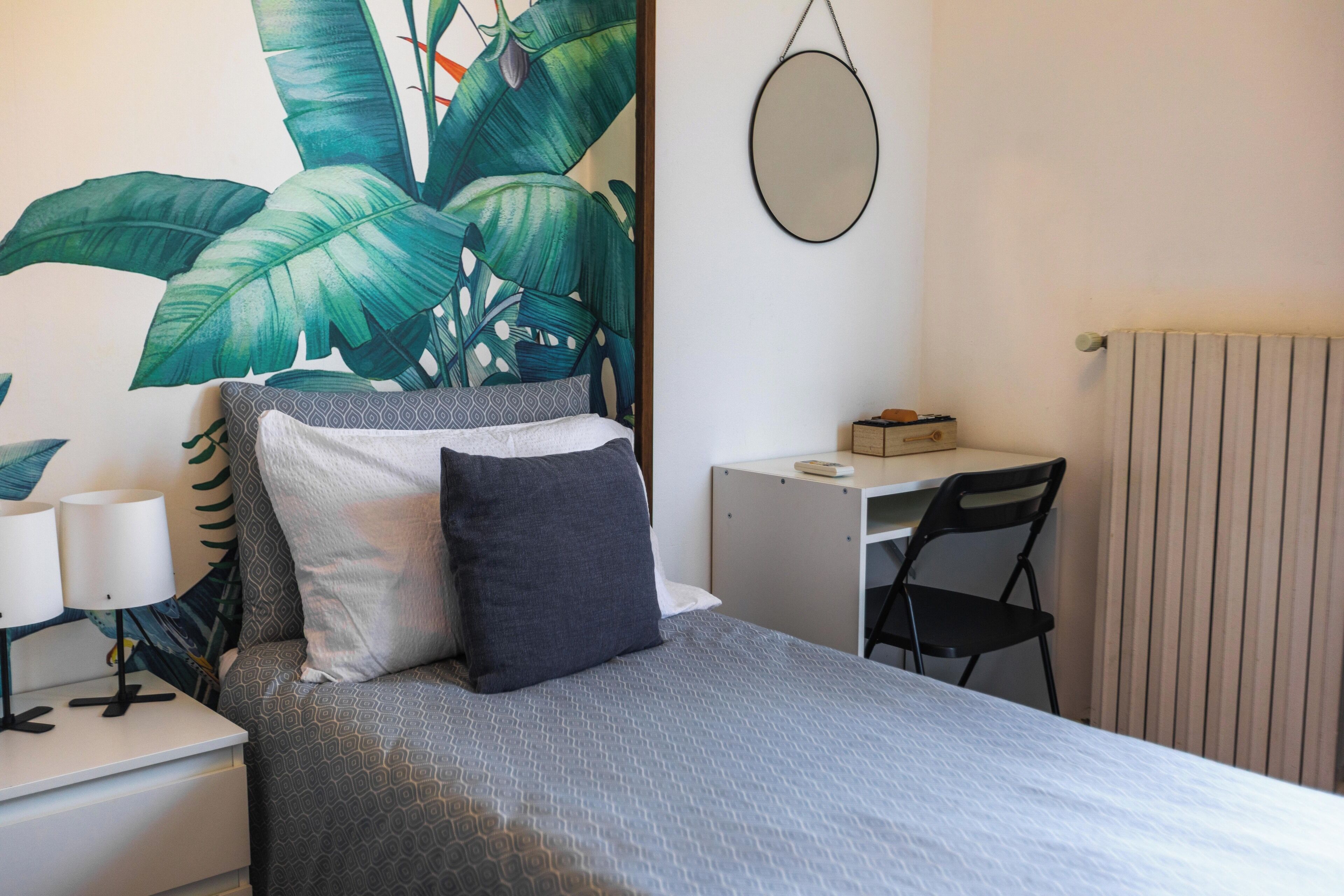 Un dormitorio ordenado con una cama, un escritorio y una silla.