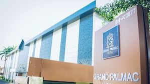 The exterior of the Grand Palmac Hotel with a prominent sign displaying the hotel's name and logo. - Grand Palmac Hotels (Abuja)