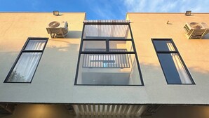 Ein Gebäude mit der Aufschrift "AWA House Hotel", mit modernem Design, großen Fenstern und Klimaanlagen.