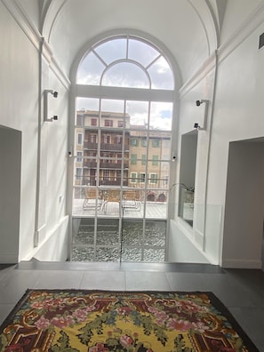 A room with a large arched window, a tiled floor, and a patterned rug. - Best Western Grand Hotel de Castres (Castres)