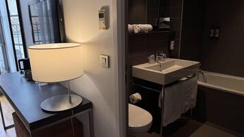Une salle de bain moderne avec un lavabo, des toilettes et une baignoire.