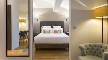 Ein Hotelzimmer mit Bett, Nachttischlampen, einem Sessel und einem Spiegel, der den Raum wiedergibt.